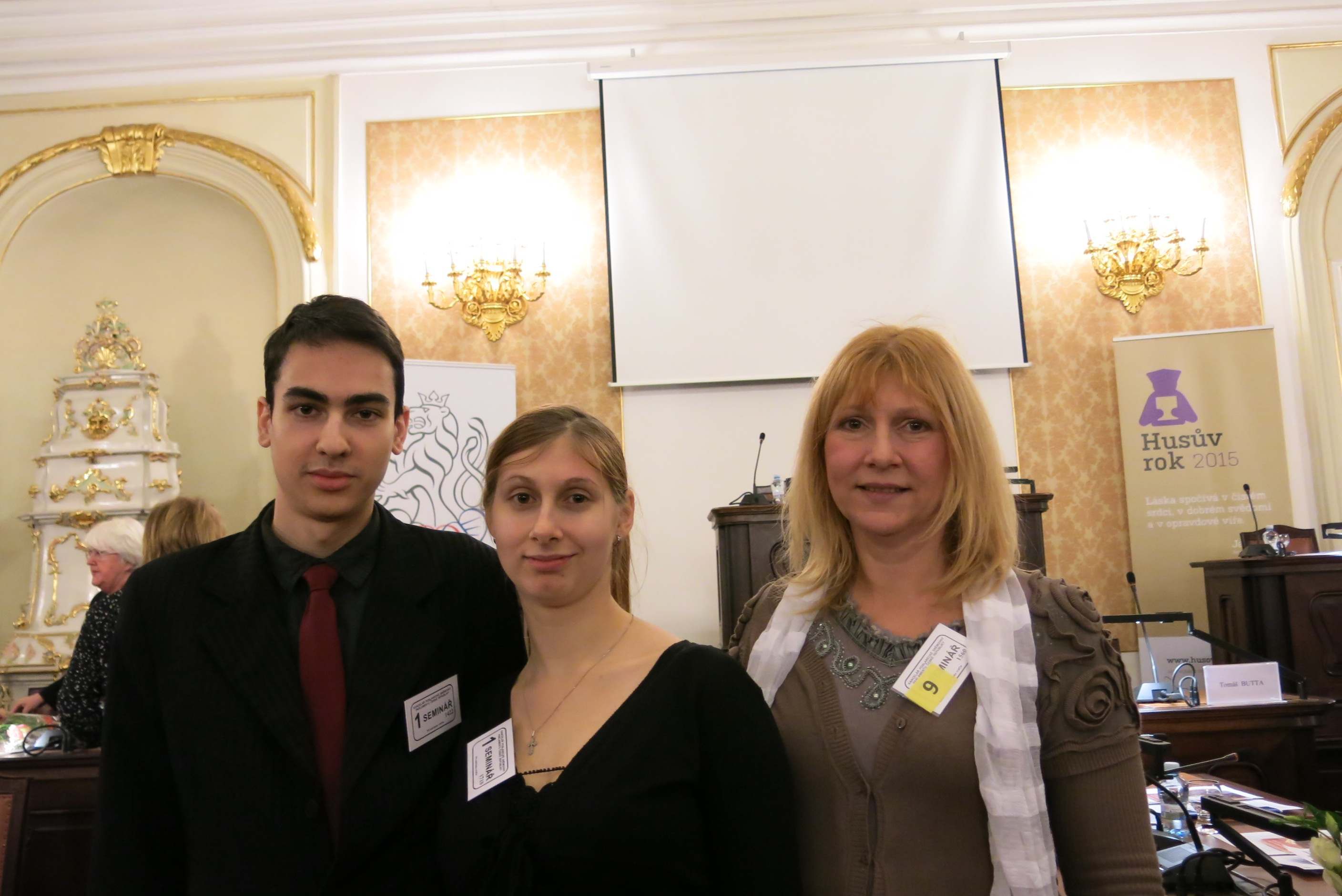 V. Mottl, Š. Pikálková, M. Pikálková před předsednickým stolem